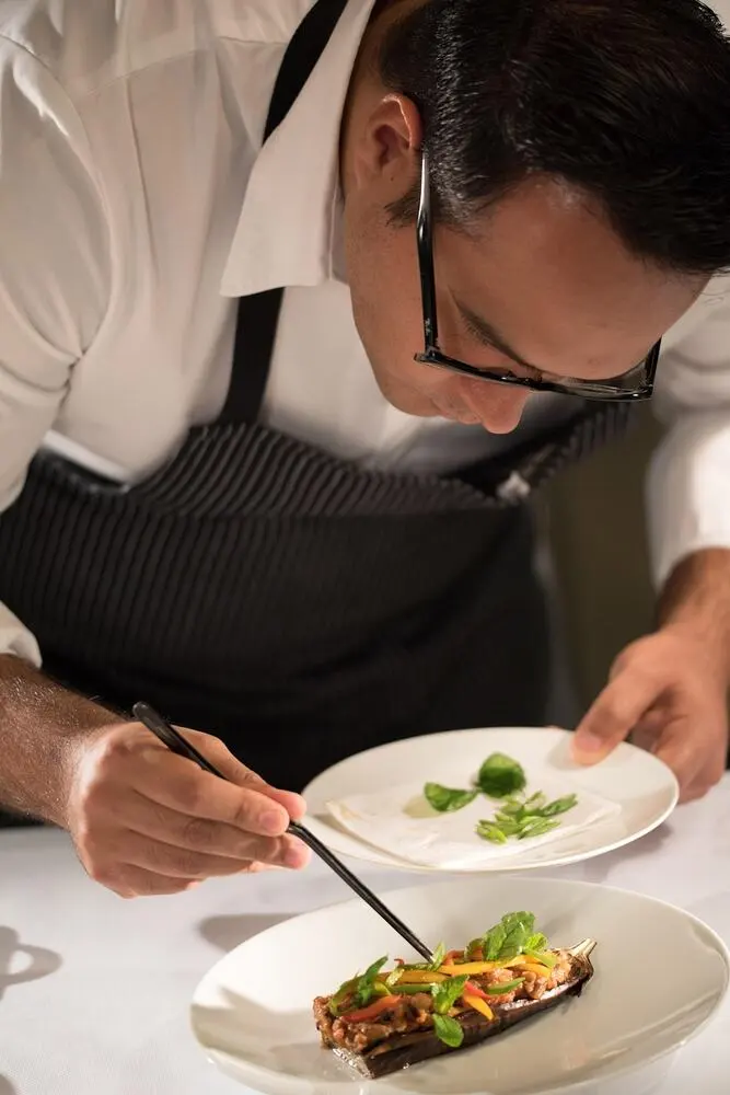 Chef precisely plating a fine dining dish