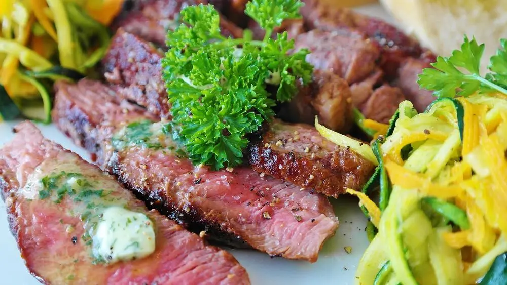 Sliced Highland venison with herb butter and vegetables
